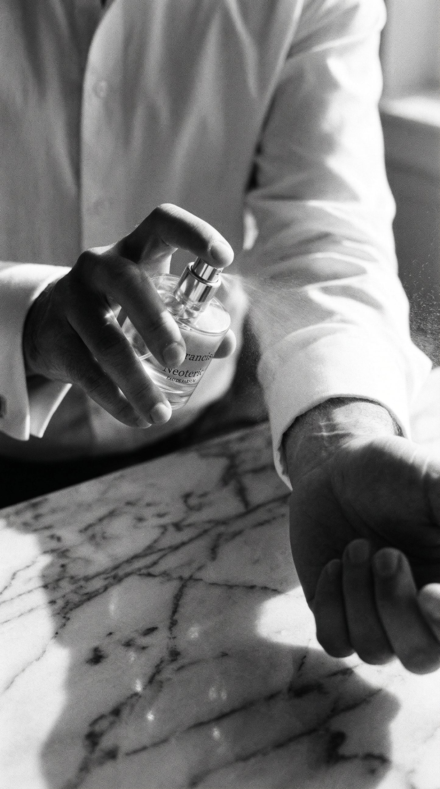 Person holding a glass of water on a marble surface