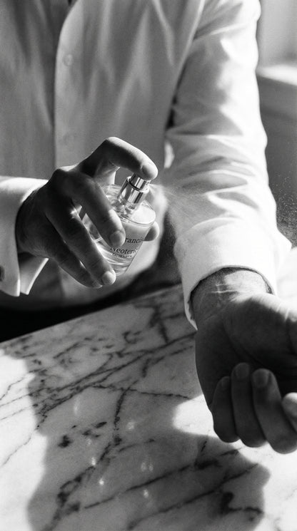 Person holding a glass of water on a marble surface